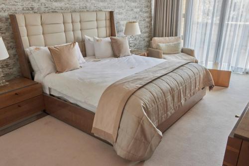 哈里史密斯Mseleku Villa的一间大卧室,配有一张大床和一把椅子