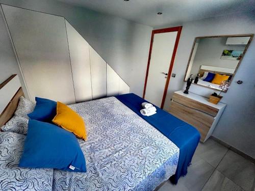 马斯帕洛马斯Chalet Privato con Jacuzzi New的一间卧室配有蓝色和黄色枕头的床