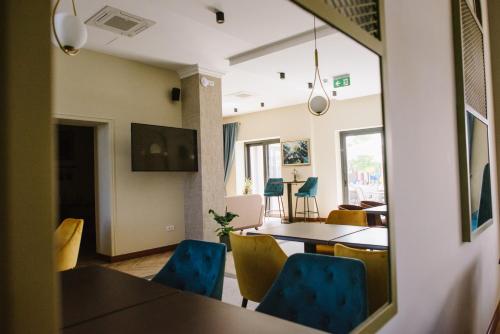 苏博蒂察AVIOR Garni Hotel的一间设有蓝色椅子和镜子的用餐室