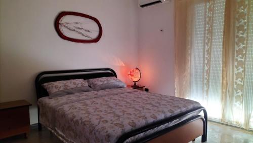 布林迪西Casa Vacanza Casale的卧室配有一张床,墙上挂着一个钟