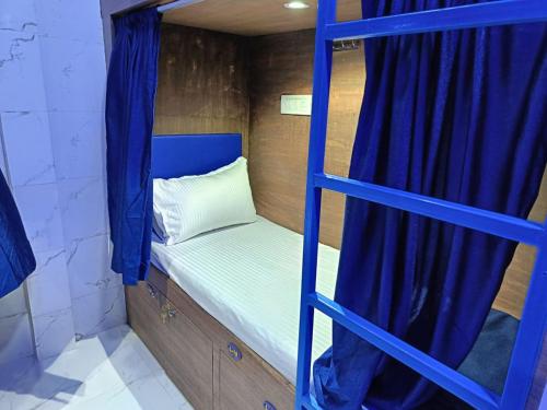 孟买Kohinoor Dormitory的客房内的一张带蓝色梯子的双层床