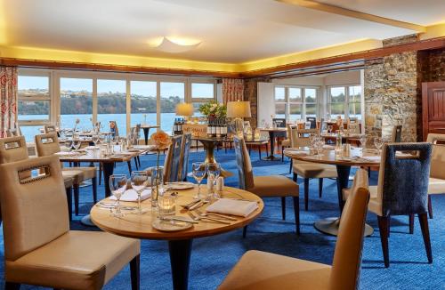 金塞尔Trident Hotel Kinsale的一间设有桌椅并享有水景的餐厅