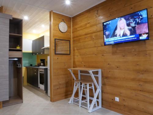 埃格勒通Studio Ventadour的木墙上配有电视的厨房