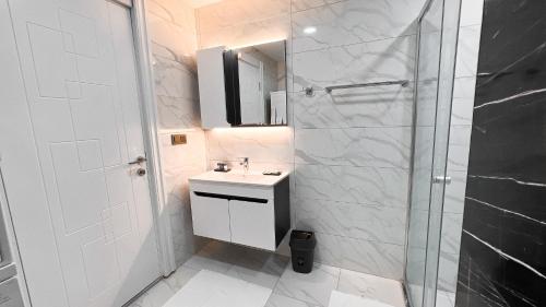 伯萨BMB GROUP HÜRRİYET HOME的白色的浴室设有水槽和淋浴。