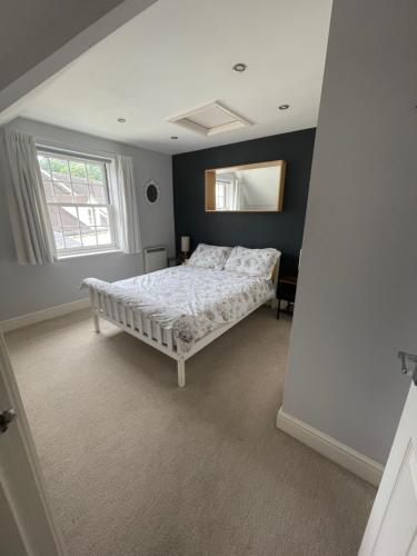 内尔斯沃思Modern loft retreat in the heart of Nailsworth的卧室配有一张床,墙上设有镜子