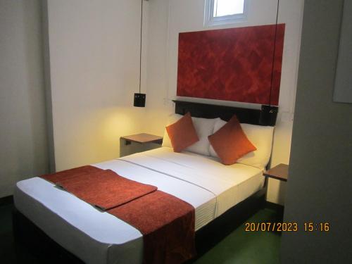 康提My city Beds的配有橙色枕头的床的酒店客房