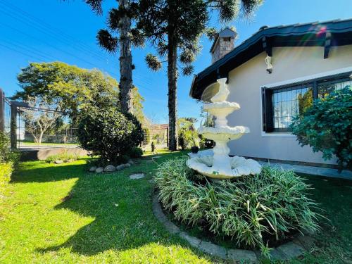 卡内拉Residencial Pine House的房屋院内的一个白色喷泉