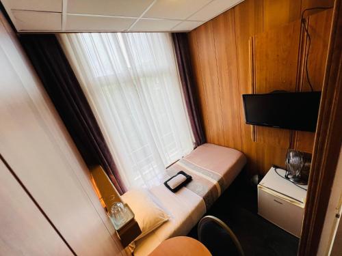 阿姆斯特丹沙姆沙伊赫酒店的一个小房间的小床,设有窗户