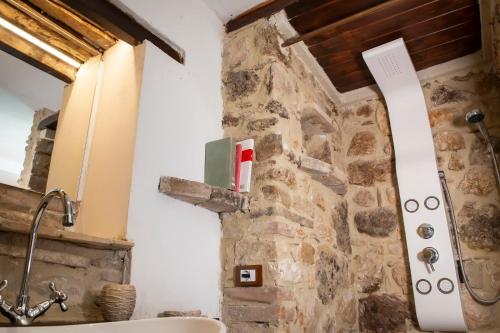 斯波莱托Volver B&B Spoleto的一间带石墙和水槽的浴室