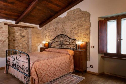 斯波莱托Volver B&B Spoleto的一间卧室设有一张床和石墙