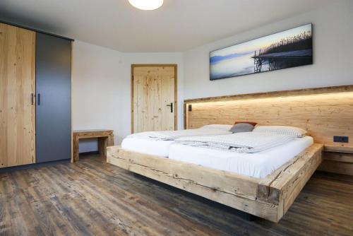 希明格Beim Lenglacher的一间卧室配有一张大床和木制床头板