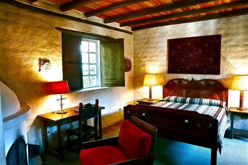奥塔瓦洛库辛庄园酒店的一间卧室配有一张床、一张桌子和一把椅子