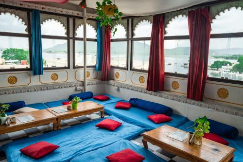 乌代浦Dreamyard Udaipur的一间设有蓝色桌子和红色枕头的客房