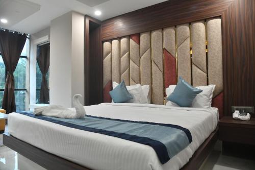 德奥加尔City Square的一间卧室配有一张大床和木制床头板