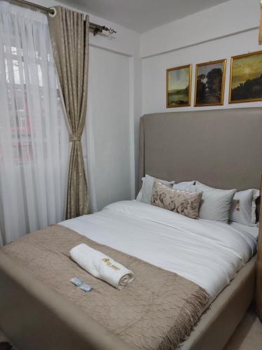 KerichoZoe Homes Oak Villa Apartment 1 and 2 Bedroom 201的一张带两条毛巾的床和窗户