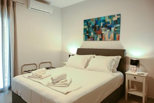 拉里萨Larisa Hospitality II - St Nicholas apartment - with Free Parking的一间卧室配有一张床,上面有两条毛巾