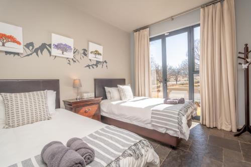 德尔斯特鲁姆109 Upwood的一间卧室设有两张床和窗户。