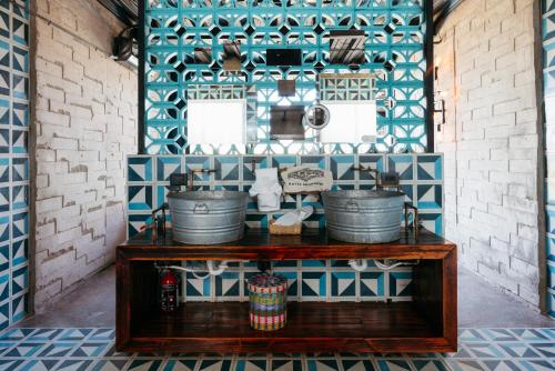瓜达鲁佩镇Hotel Los Amantes Valle de Guadalupe的厨房的墙壁上铺有蓝色和白色的瓷砖。