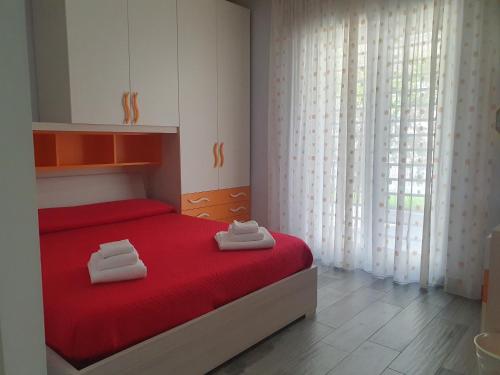 波佐利Villa Giulia的一间卧室配有红色的床和2条毛巾