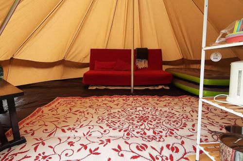 SchagerbrugSfeervolle Tipi tent dicht bij de kust.的帐篷内一张红色沙发