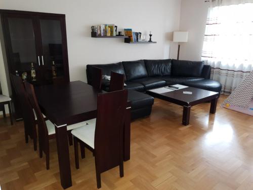 克拉科夫Apartament Alutka的客厅配有黑色沙发和桌子