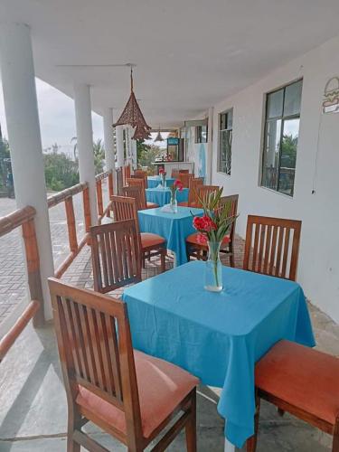 通贝斯La palmera zorritos的一间设有蓝色桌椅和花瓶的餐厅