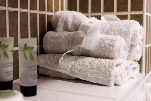 艾尔斯伯里Comfortable 4-Bedroom Home in Aylesbury Ideal for Contractors Professionals or Larger Families的浴室柜台上摆放着一堆毛巾