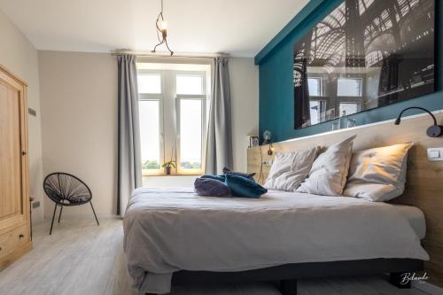 夫洛雷恩LE MANOIR DE LA VALETTE的一间卧室设有一张蓝色墙壁的大床