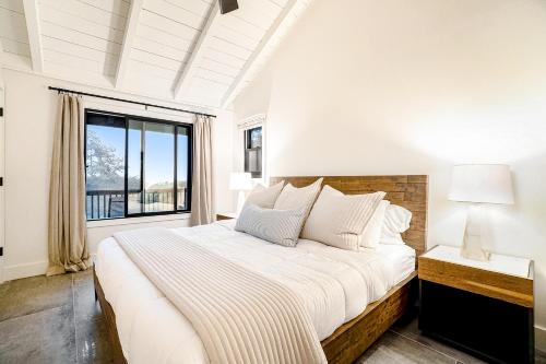马尼斯蒂Dune House的白色的卧室设有一张大床和一个窗户