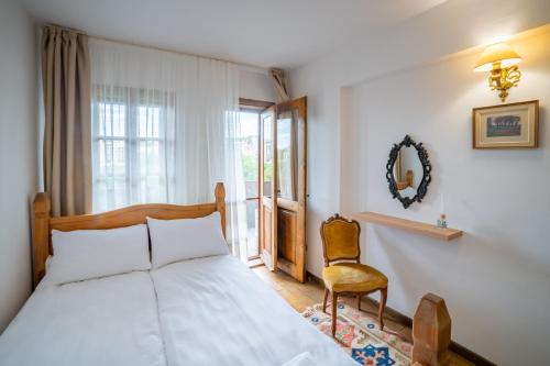 大特尔诺沃Four Riders Guest House的卧室配有床、椅子和窗户。