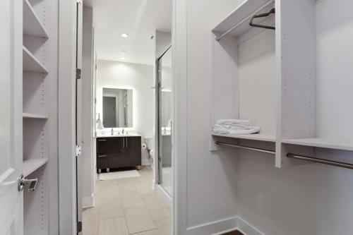 亚特兰大Midtown Luxury Apartment的浴室设有白色橱柜和步入式衣柜。
