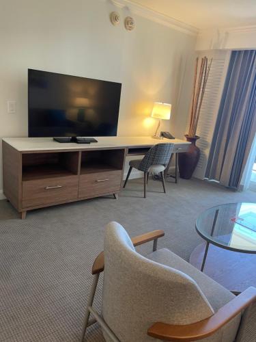 劳德代尔堡The Atlantic Hotel & Spa Condo的客厅配有书桌、电视和椅子