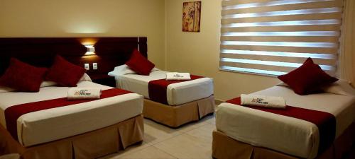 塔里哈Hotel Las Pascuas的酒店客房设有两张床和窗户。
