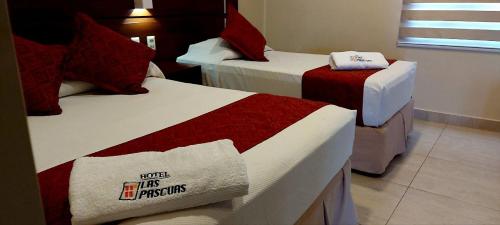 塔里哈Hotel Las Pascuas的酒店客房,配有两张带红白毯子的床