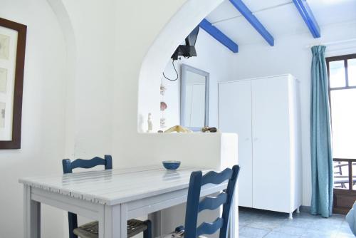 基斯诺斯Martinos Studios的一间配备有白色桌子和蓝色椅子的用餐室