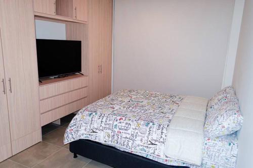 圣玛尔塔Apartamento santa marta的一间卧室配有一张床和一台平面电视