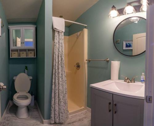 巴港3 Bedroom Pool PlayArea CampFire Cozy Apt的一间带卫生间、水槽和镜子的浴室
