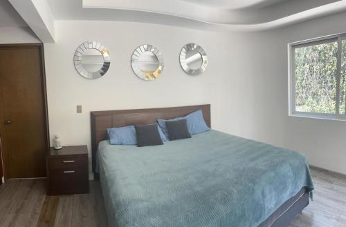 墨西哥城Casa helenico的卧室配有一张床,墙上有三面镜子