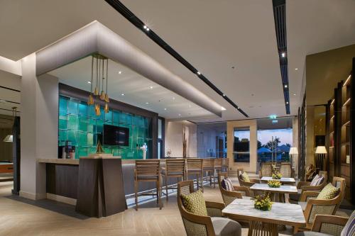 七岩Sheraton Hua Hin Resort & Spa的一间带桌椅的餐厅和一间酒吧