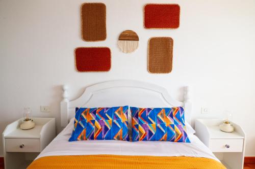 巴哈马尔Apartamento Maye的卧室配有一张带彩色枕头的床铺,墙上设有枕头