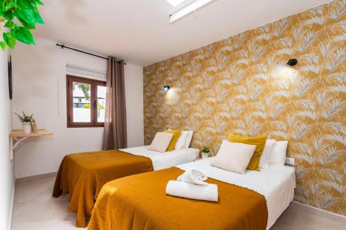 亚伊萨Casa Volcán y Mar的酒店客房带两张带黄床单的床