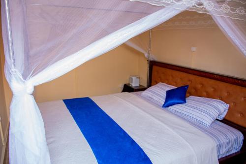 布琼布拉B I G Residence Hotel的一间卧室配有蓝白色床和天蓬
