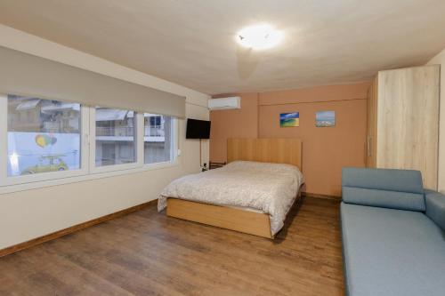 卡瓦拉FAOS Properties的一间卧室设有床、窗户和沙发
