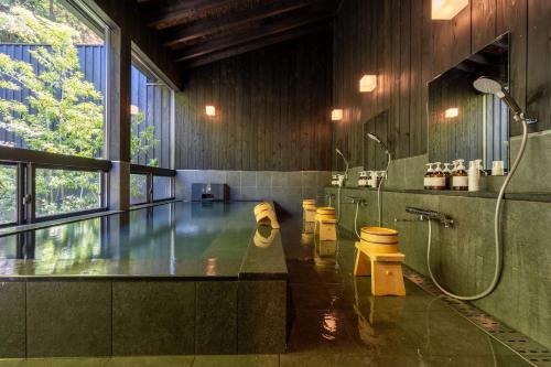 上田市Bessho Onsen Midoriya的带淋浴和盥洗盆的大浴室