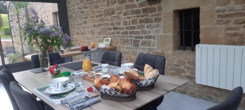 LonnyLe Moulin d'Harcy的一张木桌,上面有面包篮子