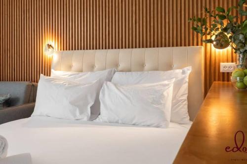 埃拉特Luxury living 100 meter from the beach - by Edom的卧室配有带白色枕头和桌子的床