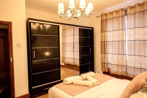 伦敦Spacious 2 Bedroom Flat的一间卧室设有一张床、一个窗户和一个吊灯。