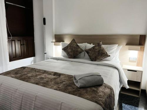 帕斯托hotel versalles的卧室配有一张带白色床单和枕头的大床。