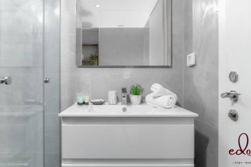 埃拉特דירה יוקרתית 100 מטר מהים - By Edom的白色的浴室设有水槽和淋浴。