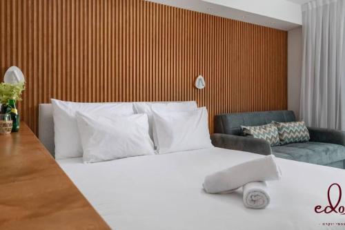 埃拉特דירה יוקרתית 100 מטר מהים - By Edom的卧室配有白色的床和沙发